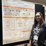 Woman standing next to scientific poster