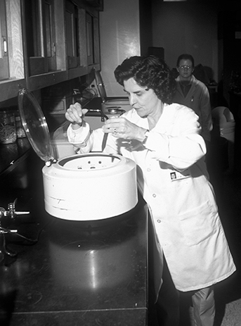 A black and white photo of Dr. Sharon Patton working with parasite sample in the lab.