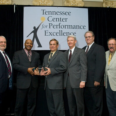 (left to right) Buddy Moore, Michael Blackwell, Dennis Geiser, Jim Brace, John New, and Leon Potgieter hold the 2003 Commitment Award 