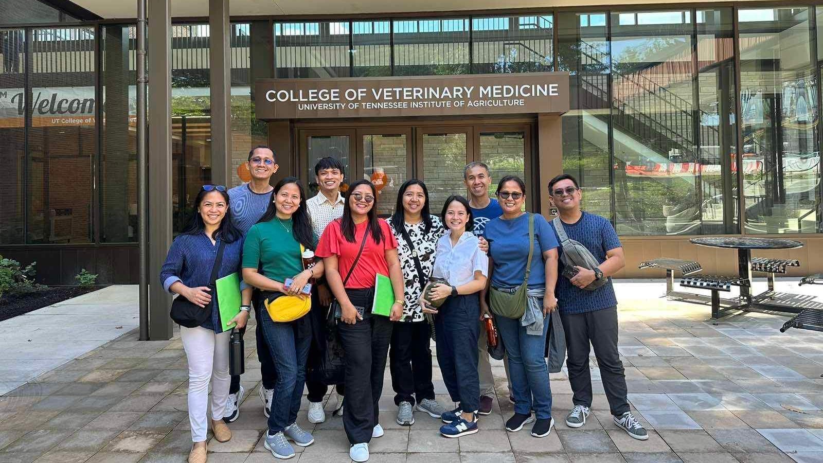 Group of 11 people standing outside the College of Veterinary Medicine