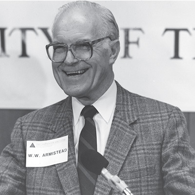 Dr. W.W. Armistead smiling on stage during an event 