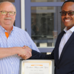 Dr. Makau receiving the Boehringer Ingelheim Graduate Advisor of the Year Award from Dr.. Anderson.