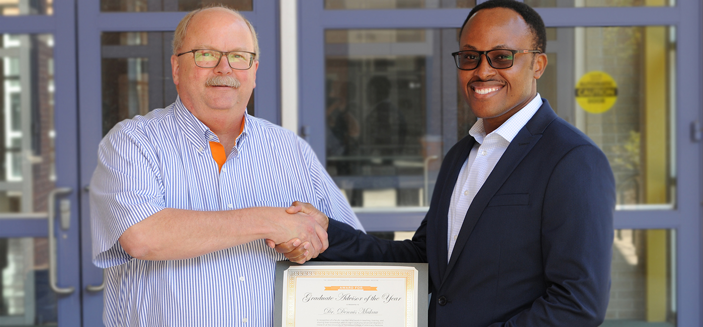 Dr. Makau receiving the Boehringer Ingelheim Graduate Advisor of the Year Award from Dr.. Anderson.