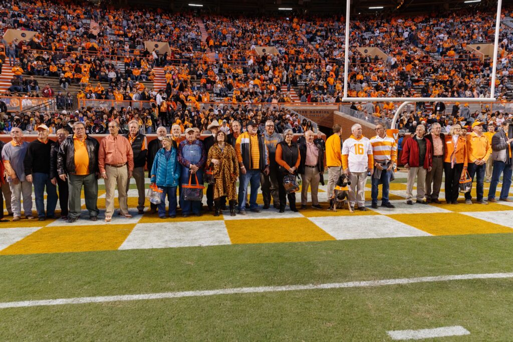 Members of the Class of 1979 stand on the orange and white checkered endzone at Neyland Stadium during a homecoming game in 2019. 
